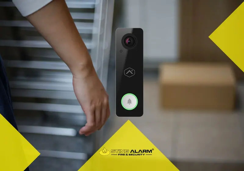 Alarm.com video doorbell beside a front door with a package on the porch